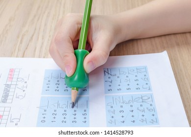 Child's Hand With Writing Tool For Help By Incorrect Holding Of Pencil, Closeup, Homewortk, Math