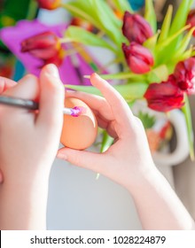 Child's Hands With A Brush Decorating An Easter Egg. Negative Space.