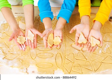 child's hands with dough over the table, top view