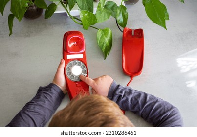 child's hands and hair using an antique red phone at home - Powered by Shutterstock