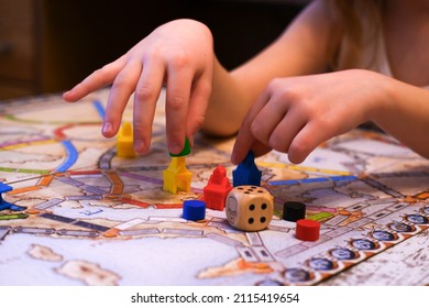 the child's hands hold colored chips on the playing field, board games, a game cube