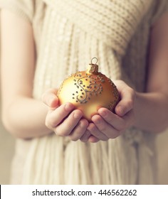 Child's hands holding Christmas ornament

