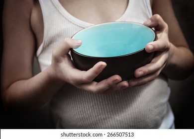 Child's hands holding an empty bowl.  Hunger 