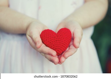 Child's Hands Holding Knitted Heart