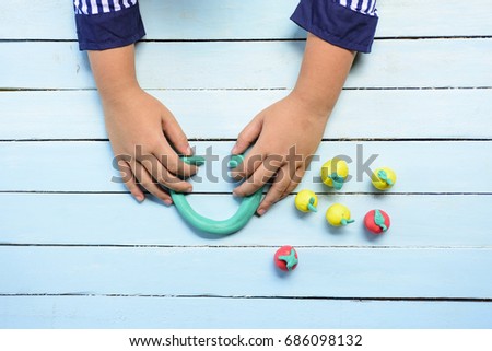Child's hands playing Clay and using creativity for making line and fruits,Such as orange and etc.2