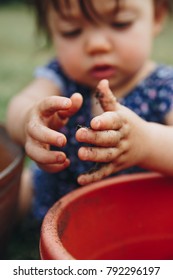 Child's Hands Playing In Garden Dirt