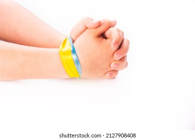 The child's hands are tied together with ribbons in the color of the flag of Ukraine. Conflict between Russia and Ukraine. War 2022. isolated white. Copy space