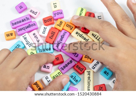 Child's hands with word blocks on white background 