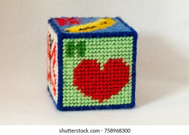 Child's Needlepoint Alphabet Block With Letter H And Image Of A Heart. White Background.