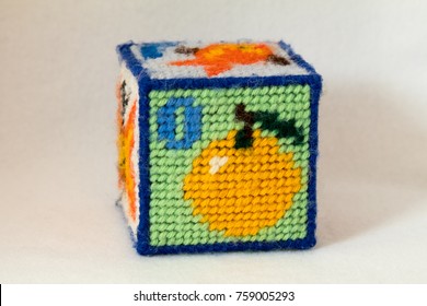 Child's Needlepoint Alphabet Block With Letter O And Image Of An Orange. White Background.