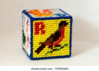 Child's Needlepoint Alphabet Block With Letter R And Image Of A Robin. White Background.