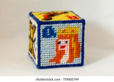 Child's Needlepoint Alphabet Block With Letter Q And Image Of The Face Of A Queen With Crown. White Background.