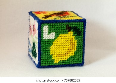 Child's Needlepoint Alphabet Block With Letter L And Image Of A Lemon. White Background.