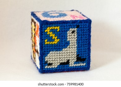 Child's Needlepoint Alphabet Block With Letter S And Image Of A Seal. White Background.