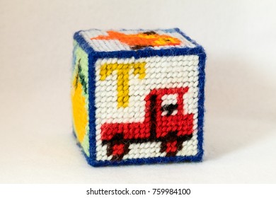 Child's Needlepoint Alphabet Block With Letter T And Image Of Truck. White Background.