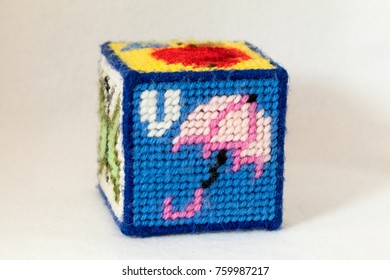 Child's Needlepoint Alphabet Block With Letter U And Image Of Umbrella. White Background.