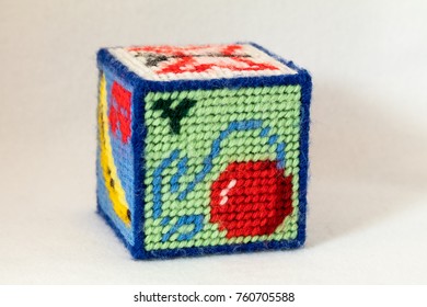 Child's Needlepoint Alphabet Block With Letter Y And Image Of A Ball Of Yarn. White Background.