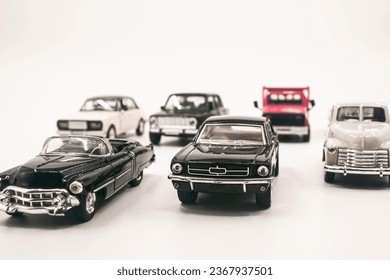 It's child's play. Small metal toy cars on white background. Photograph.
