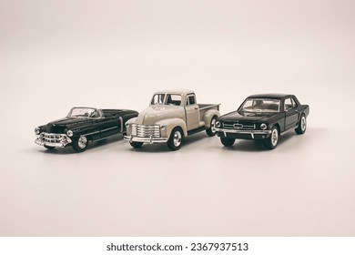 It's child's play. Small metal toy cars on white background. Photograph.