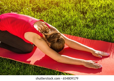 Child's Pose. Practicing Yoga In The Park