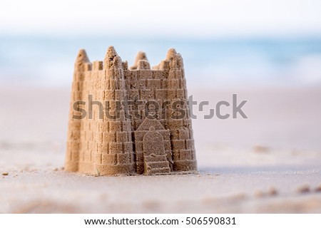 A Childs sand castle waiting for the  ocean tide to come in to reclaim it 