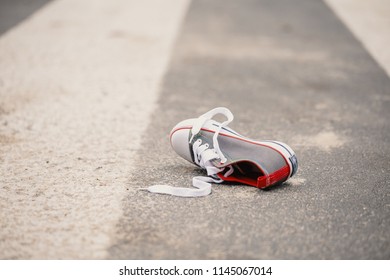 Child's Shoe On The Street After Dangerous Traffic Incident