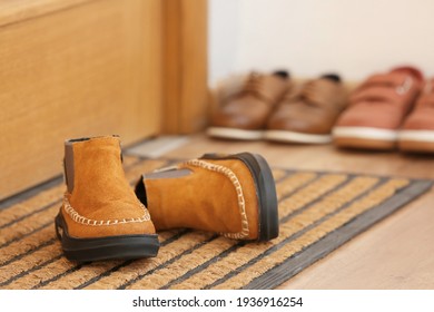 Child's Shoes Near Door On Mat