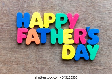 Child's toy letters spelling Happy Fathers Day over wooden background