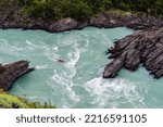 Chile, Aysen. Whitewater kayaker paddling through a canyon on the Baker River.