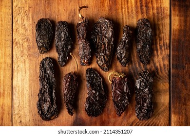 Chile Morita. This Mexican chili is the dried and smoked form of jalapeÃ±o chili and are used in a variety of Mexican preparations. top view image on rustic wooden board.  - Powered by Shutterstock