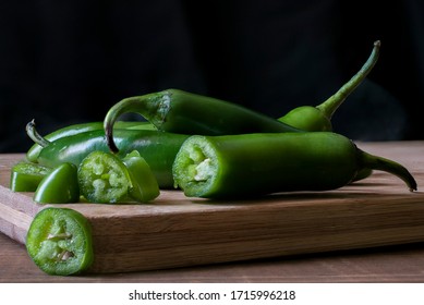Chile serrano or serrano chilis on a wooden cutting board in a black background, ingredients for Mexican food cuisine. dark food or low key light photography, chiaroscuro technic - Shutterstock ID 1715996218