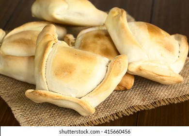 Chilean Empanada, A Baked Pastry Stuffed With Meat, Photographed With Natural Light (Selective Focus, Focus On The Empanada In The Front)