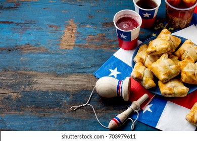 Chilean independence day concept. fiestas patrias. Chilean typical dish and drink on independence day party. Mini empanadas, mote con huesillo, wine with toasted flour chicha and tipical play emboque.