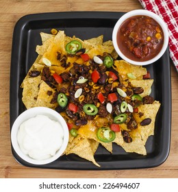 Chili And Cheddar Cheese Nacho Platter With Fresh Tomatoes, Onions, Jalapeno Peppers, Sour Cream And Salsa