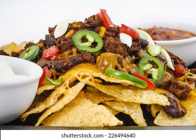 Chili And Cheddar Cheese Nacho Platter With Fresh Tomatoes, Onions, Jalapeno Peppers, Sour Cream And Salsa