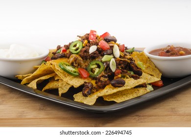 Chili And Cheddar Cheese Nacho Platter With Fresh Tomatoes, Onions, Jalapeno Peppers, Sour Cream And Salsa