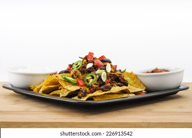 Chili And Cheddar Cheese Nacho Platter With Fresh Tomatoes, Onions, Jalapeno Peppers, Sour Cream And Salsa