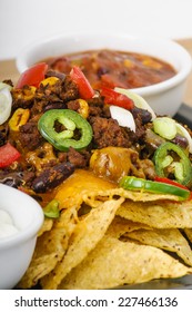 Chili And Cheddar Cheese Nacho Platter With Fresh Tomatoes, Onions, Jalapeno Peppers, Sour Cream And Salsa