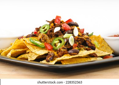 Chili And Cheddar Cheese Nacho Platter With Fresh Tomatoes, Onions, Jalapeno Peppers, Sour Cream And Salsa