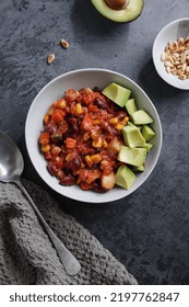 Chili Con Carne With Avocado Served On Plate On Grey Background. 