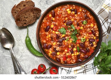 Chili con carne in a clay bowl on a concrete or stone rustic background- traditional dish of mexican cuisine.Top view. - Shutterstock ID 512602867