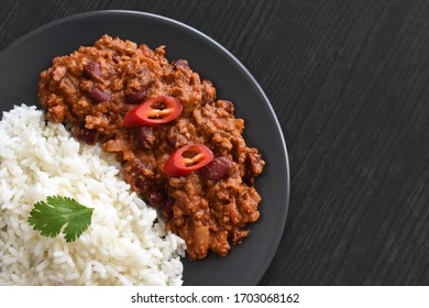 Chili con carne with rice on wood table.  Copy space is on the right side.  Selective focus.