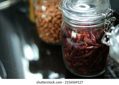 Chili And Groundnut. Dried Chili In Glass Jar With Lid In Kitchen Counter. Raw Materials For Cooking. Health Food Ingredient Image For Interior Design, Background, Book, Website, Cover Page. 