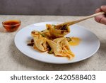 Chili Oil Wontons are a Chinese dumpling dish often served in soup or fried. Wonton filling usually consists of a mixture of minced meat (such as chicken or shrimp) and spices.