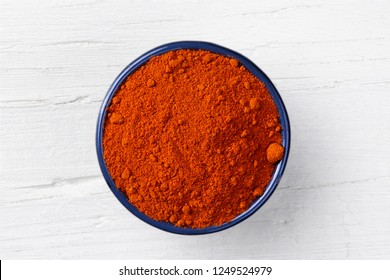 Chili Paprika Powder In Cast Iron Bowl On White Wooden Background, View Directly From Above.