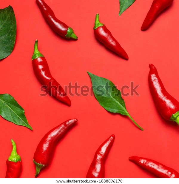 Chili peppers background. Hot red and green fresh\
chili peppers on red background flat lay top view. Seasoning for\
dish, spicy spices for cooking, cayenne pepper, food. Creative\
layout, chili pattern