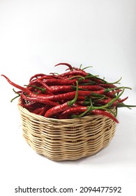 Chili. Red Chili. Capsicum. Capsicum annuum L. Close viev and Selective Focus on Fresh Red Chili in the rattan wicker basket. Isolated on White Background. Hot. Spicy. Ingredient. Vegetables. Chilli. 