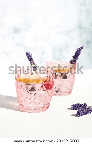 Chilled cocktail with lavender and citrus. Summer drink, soda with lemon and sprig of lavender on a bright sunny day. Detox water with citrus