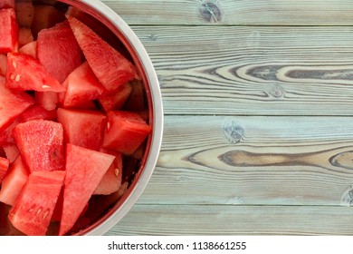 Chilled Metal Bowl Full Of Diced Fresh Juicy Watermelon For A Refreshing Summer Dessert On A Weathered Pine Wood Picnic Table With Copy Space