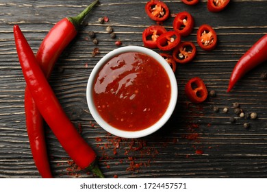 Chilli Pepper And Bowl Of Sauce On Wooden  Background, Top View